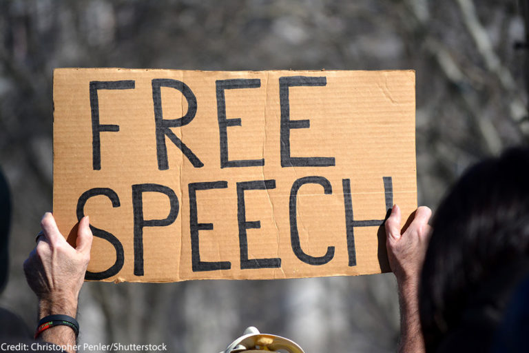 A protest sign that reads "free speech"