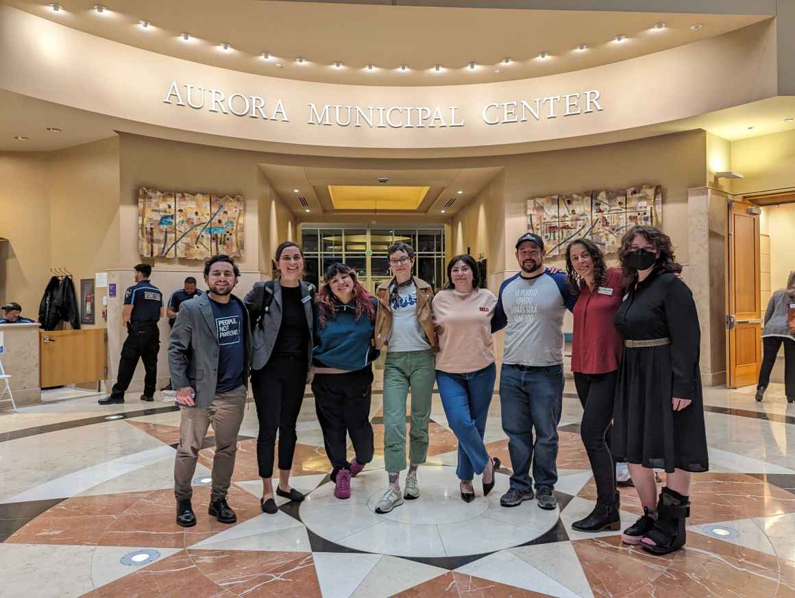 Photo of activists standing inside the Aurora Municipal Center, looking at the camera and smiling