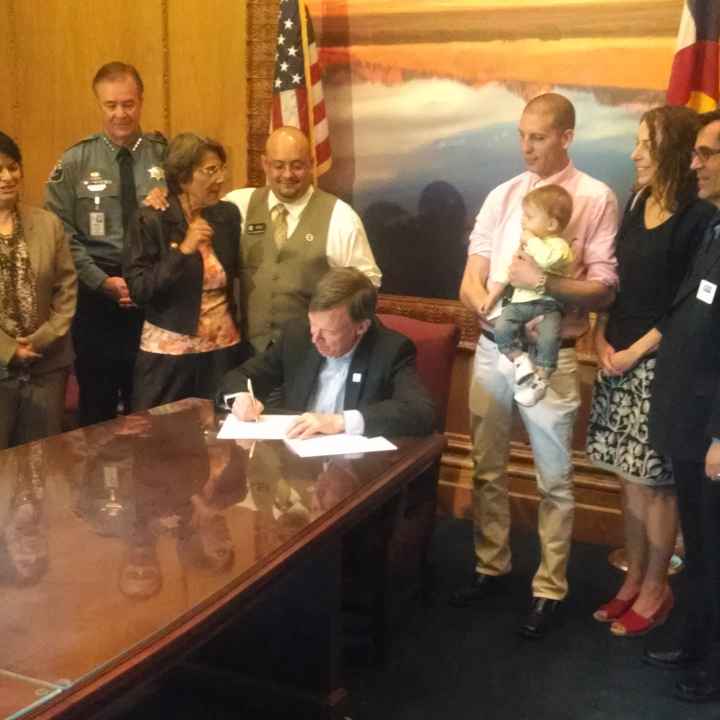 Public Policy Director Denise Maes, Sen. Guzman, Rep. Salazar, Gov. Hickenlooper, Jared Thornburg, Staff Attorney Rebecca Wallace, and Executive Director Nathan Woodliff-Stanley at the bill signing